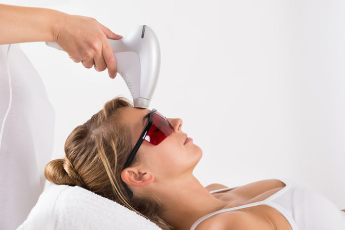 Woman Undergoing Laser Treatment At Salon