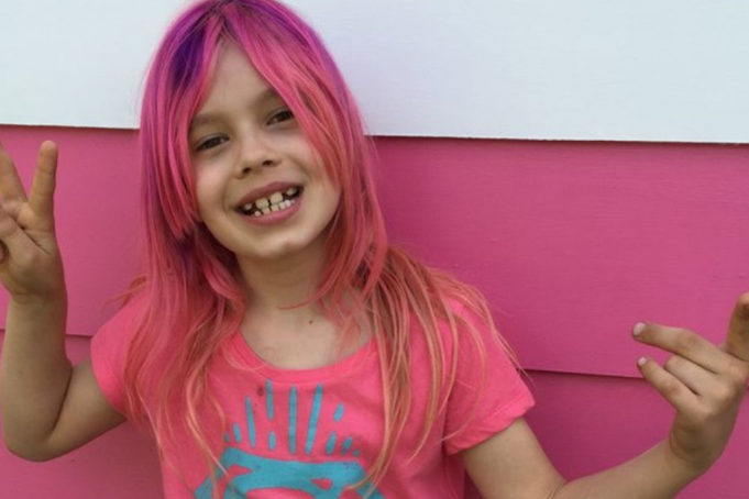 Photo of Avery Jackson giving a peace sign and wearing a pink Super Girl Shirt - The family of the 9-year-old transgender girl who is featured on the cover of National Geographic has been dealing with cyber bullying and threats.