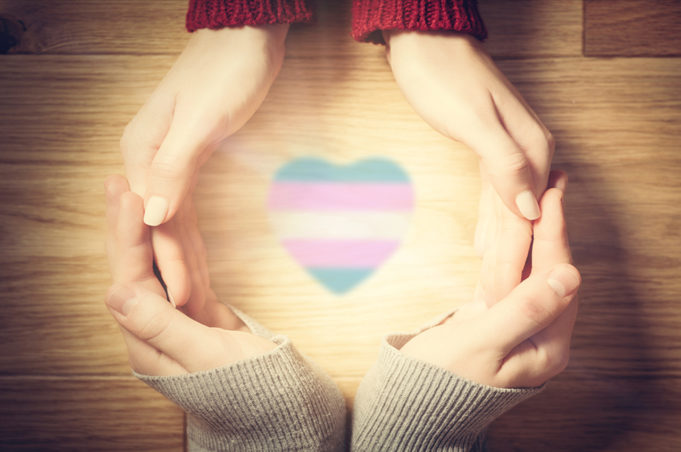 Parents making circle with hands with a transgender flag colored heart revealing light in the middle. - Love and Light - Having a gay or transgender child says nothing about your parenting efforts, but disowning them does show a lot about your parenting failures.