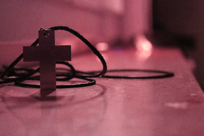 Metal Cross Necklace on a shelf - Massachusetts Churches Drop Anti-Transgender Lawsuit- Four churches in Massachusetts dropped a lawsuit that was filed in reaction to the state’s transgender protections bill after being informed they were exempt from the law.