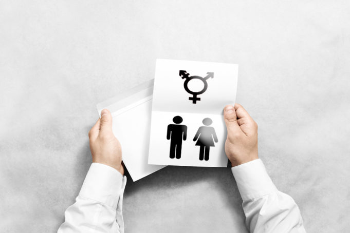 Hand holding white blank envelope and letter mockup with transgender and male/female symbols on it. -The trans guy next door makes his case for why we don’t need transgender restroom legislation. An open letter by Bailey C.